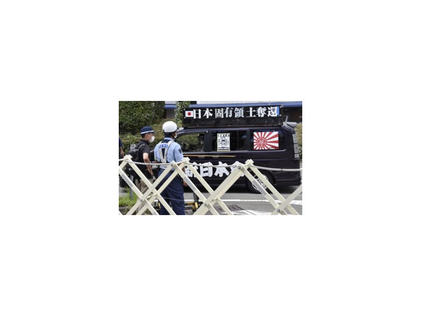 展示の中止を求める街宣車と警戒に当たる兵庫県警の警察官＝10日午後、神戸市