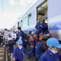 津波避難訓練で、緊急停止した列車から避難する園児ら＝5日午前、和歌山県広川町