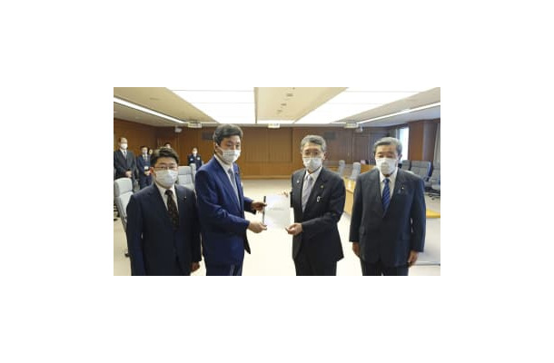 馬毛島への自衛隊基地建設計画を巡り、岸防衛相（中央左）に要望書を手渡す鹿児島県西之表市の八板俊輔市長（同右）＝3日午後、防衛省