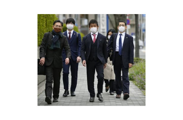 提訴のため、大阪地裁に向かうプレサンスコーポレーションの山岸忍前社長（中央）ら＝29日午前