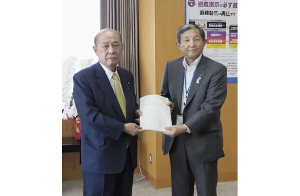 二之湯防災相（左）に要望書を手渡した和歌山県の仁坂吉伸知事＝2日午後、内閣府