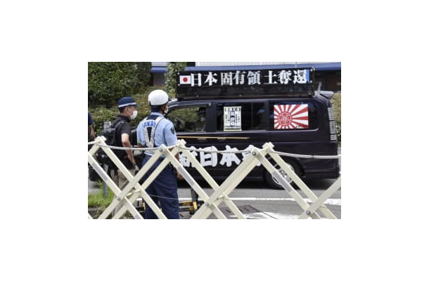 展示の中止を求める街宣車と警戒に当たる兵庫県警の警察官＝10日午後、神戸市