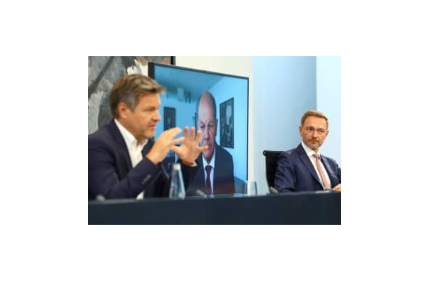 29日、エネルギー価格高騰対策などについてオンラインで記者会見するドイツのショルツ首相（中央）ら（ロイター＝共同）