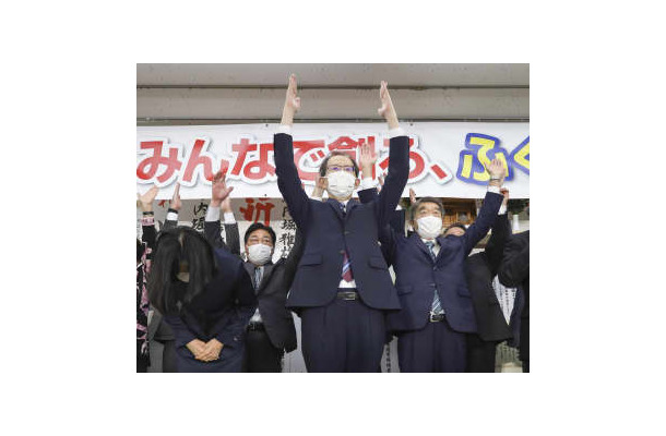 福島県知事選で3選を果たし、万歳する内堀雅雄氏（中央）＝30日夜、福島市