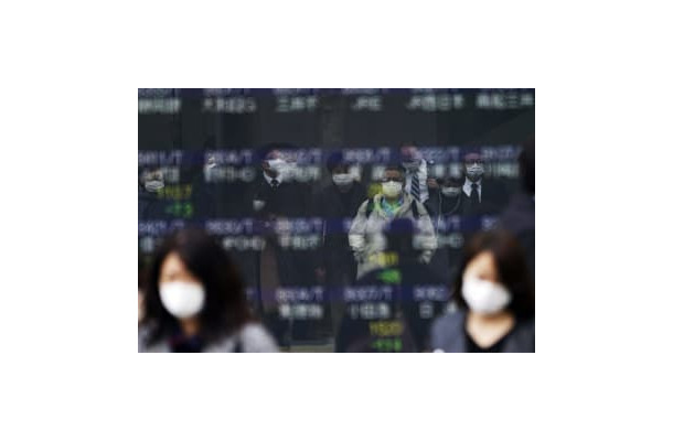 13日、東京都内の株価ボードに反射して写る、マスク姿の人たち（AP＝共同）