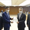 馬毛島への自衛隊基地建設計画を巡り、岸防衛相（中央左）に要望書を手渡す鹿児島県西之表市の八板俊輔市長（同右）＝3日午後、防衛省