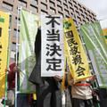 再審開始を認めない決定に、名古屋高裁前で「不当決定」と書かれた紙を掲げる弁護士＝3日午前